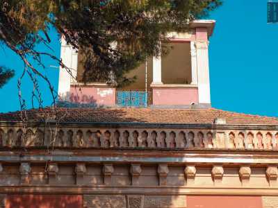 Al di sopra una merlatura marcapiano e una cornice ad archetti corrono lungo tutto il perimetro dello stabile